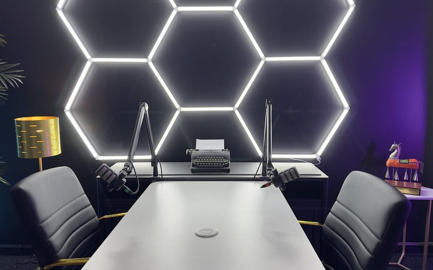 The Hive: a hexagon LED array over a white recording table that seats four